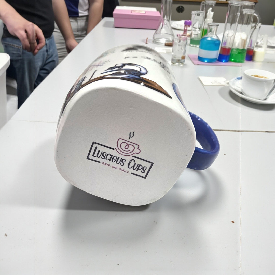 White mug with blue handle and 'Luscious Cups' logo on a white surface.
