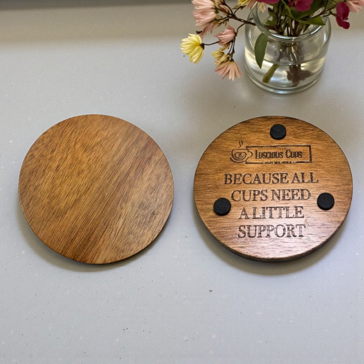Wooden coaster with text saying "Because all cups need a little support."